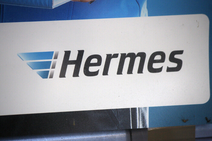 Schild, auf dem das Logo des Logistikers Hermes abgebildet ist