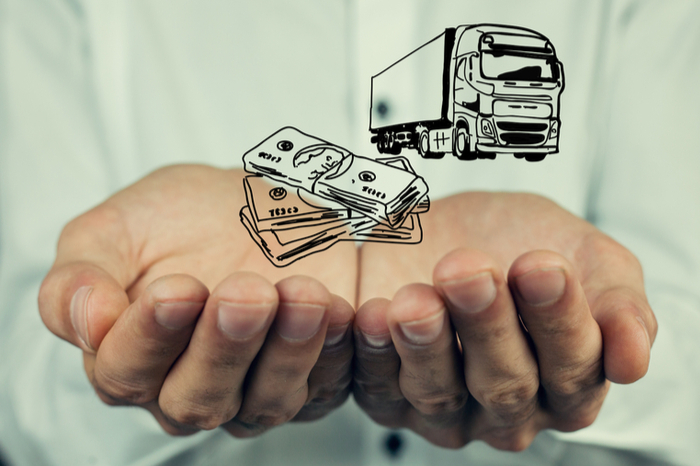 Geldscheine und Truck-Icon in Männerhand