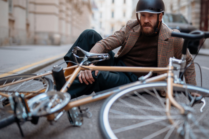 Mann liegt nach Sturz mit Retro-Bike auf der Straße